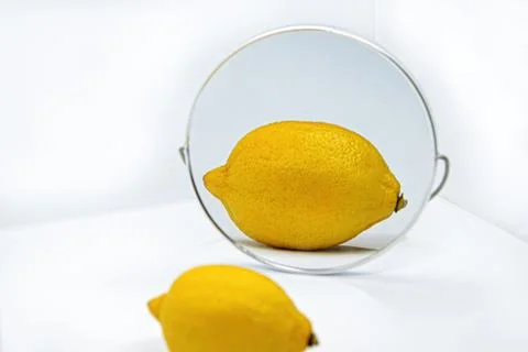 Reflection of lemon with thick peel in mirror - Metaphor of cosmetic procedur Stock Photos