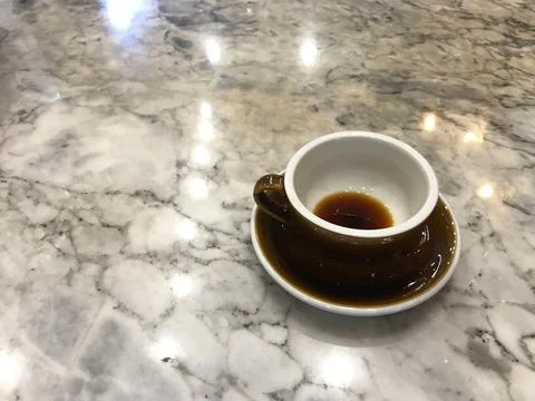 Reflection of light bulbs and a brown cup of finished coffee Stock Photos