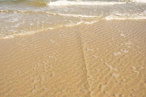 Reflection of light in sea water on a background of yellow sand Stock Photos