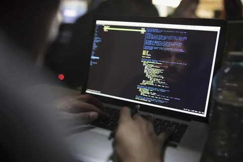 Reflection of male hacker coding working hackathon at laptop Stock Photos