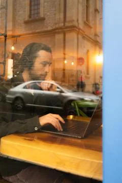 Reflection of a man with beard working with headphones and computer 写真素材