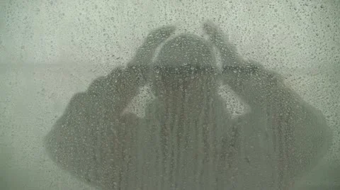 Reflection Of Man "Checking Glasses" In Water Droplet Covered Window Stock Footage 19059046