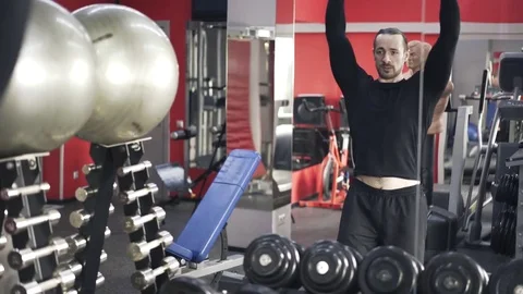 Reflection of a man doing dumbbell exercise in a gym 스톡 동영상 74428378