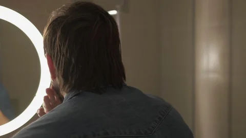 Reflection of the man fixing beard in the bathroom Stock Footage 127648886