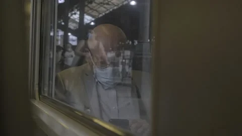 Reflection of a man reading in a train with a mask on his face,  4K, F-log Stock Footage 139173357