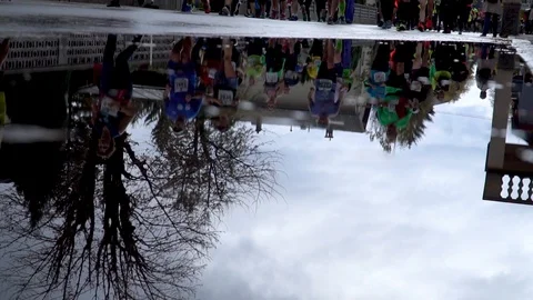 Reflection of marathon runners in a puddle in Ljubljana slowmotion Stock Footage 97463522