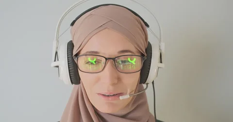 Reflection of the matrix code in glasses. Young woman in hijab is talking in Stock Footage 237743085