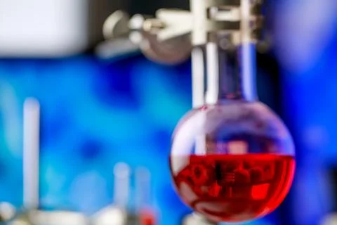 Reflection of microbe from computer screen in red reagent solution inside c.. Stock Photos