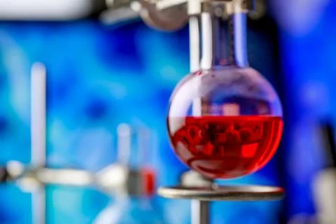 Reflection of microbe from computer screen in red reagent solution inside c.. Stock Photos