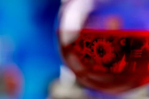 Reflection of microbe from computer screen in red reagent solution inside c.. Stock Photos