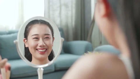 Reflection In A Mirror Beautiful Young Asian Woman Smiling After Applying Stock Footage 218321605