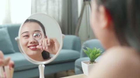 Reflection In A Mirror Beautiful Young Asian Woman Using An Eyelashes Curler Stock Footage 218321689