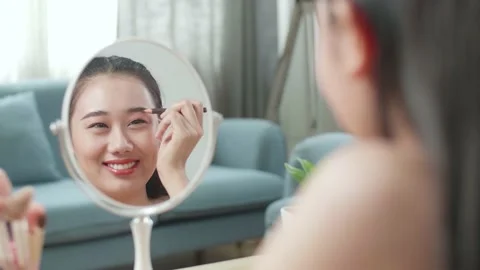 Reflection In A Mirror Beautiful Young Asian Woman Applying Eyebrow Pencil Stock Footage 218321714
