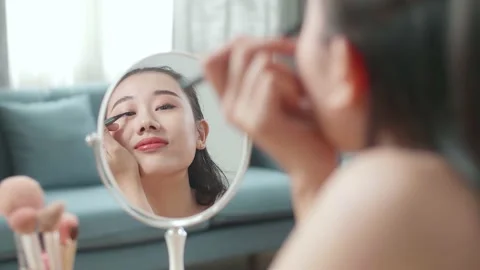 Reflection In A Mirror Beautiful Young Asian Woman Applying Eyeliner Doing Stock Footage 218321759
