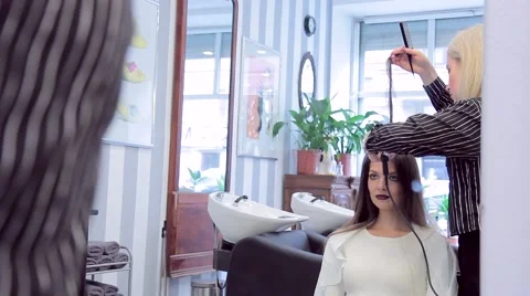 Reflection in a mirror of a beautiful young model during a barber works Stock Footage 68774632