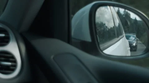 Reflection in mirror of car driving through summer landscape in faraway travel Stock Footage 284337072