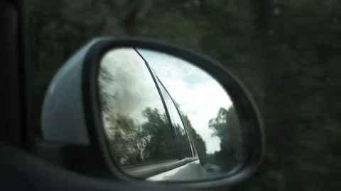 Reflection in mirror of car driving through summer or autumn landscape Stock Footage 284912138
