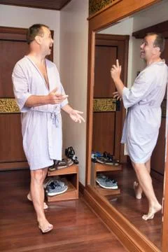 Reflection in the mirror laughs at a man in a bathrobe Foto stock