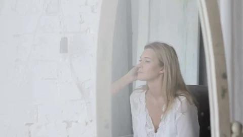 Reflection in the mirror makeup artist does makeup of girl Stock Footage 73291768