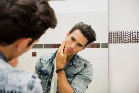 Reflection in mirror of man touching face Stock Photos