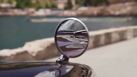 Reflection in the mirror of a retro or classic car standing on the seafront with Video stock 136766908