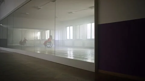 Reflection in a mirror of the woman with a disability practicing in a dance hall Stock Footage 290323951