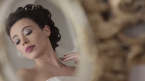 Reflection in the mirror of yound brunette bride posing in luxury interior. Video stock 103398799