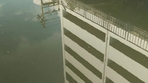 Reflection of Modern Building and Utility Poles on Calm Canal Surface Stock Footage 330516289