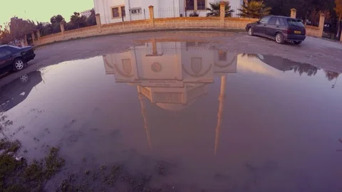 A reflection of a modern mosque in a large puddle of water in the city of Stock Footage 82107802