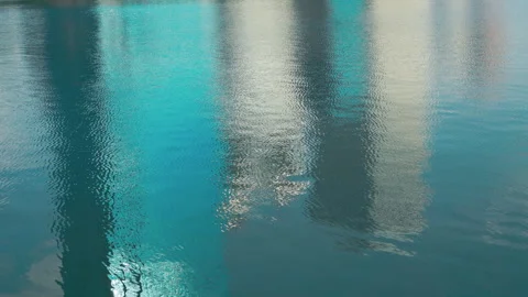 Reflection of Modern Office Buildings on Rippled Blue Water Surface Stock Footage 330924950