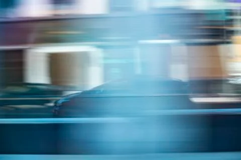Reflection of a motion blurry car or uber taxi in an buildings glass wall Stock Photos