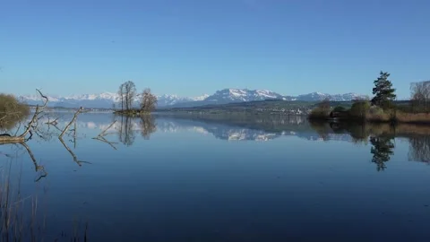 Reflection of Mount Pilatus on Lake Sempach with snowy mountains Stock Footage 332908242