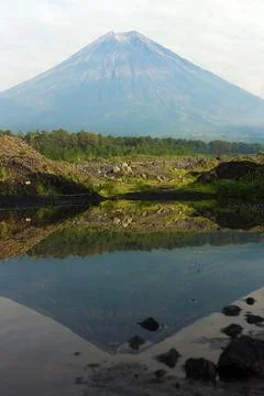 The reflection of Mount Semeru on a puddle. Stock Photos