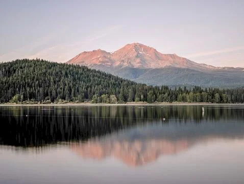 A reflection of mount shasta over a lake during sunset Stock Photos