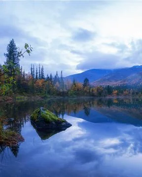 Reflection of mountains and clouds in the calm surface of the lake. Peaceful  Stock Photos