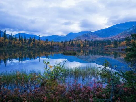 Reflection of mountains and clouds in the calm surface of the lake. Peaceful  Stock Photos