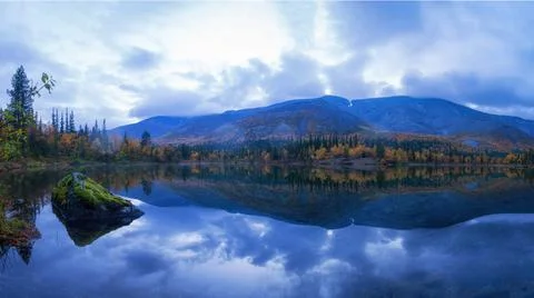 Reflection of mountains and clouds in the calm surface of the lake. Peaceful  Stock Photos