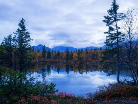 Reflection of mountains and clouds in the calm surface of the lake. Peaceful  Stock Photos