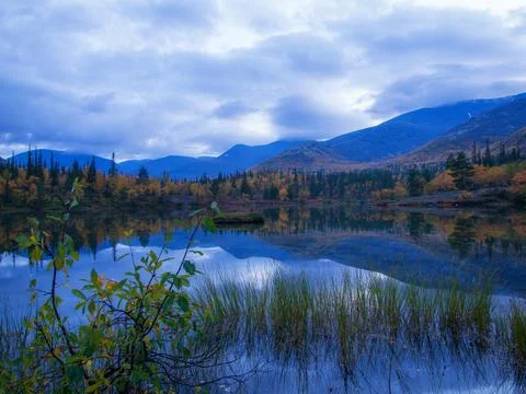 Reflection of mountains and clouds in the calm surface of the lake. Peaceful  Stock Photos