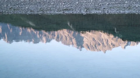 Reflection of mountains on the Nahanni River by a rocky riverbed Stock Footage 92364965