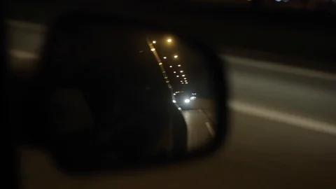 Reflection of a moving vehicle in a wing mirror. Going by car at night Stock Footage 96296691