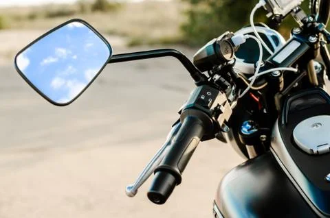 Reflection of the nab and clouds in the motorcycle mirror, motorcycle steerin Stock Photos