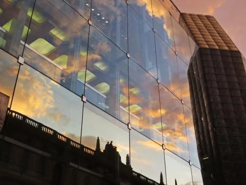 Reflection of Old Historical Building with Clouds During Sunset at Modern Gla Stock Photos