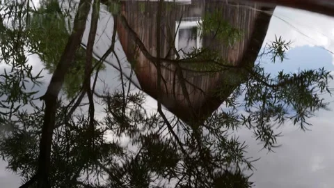 Reflection of an old rural house with tree branches in the pond is a surreal Stock-Footage 159752384