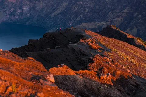 Reflection of orange sky on the summit of Mount Rinjani at sunset, Lombok Foto stock