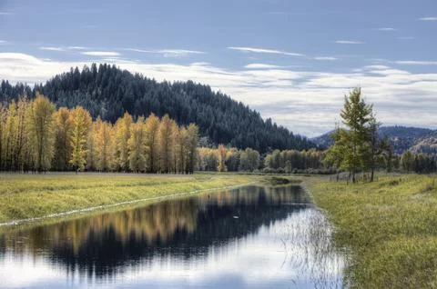 Reflection of partly cloudy sky in the water. Stock Photos