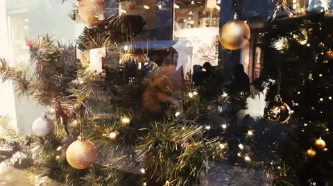 Reflection of people over Christmas tree on showcase of shop during new year Stock Footage 58952993