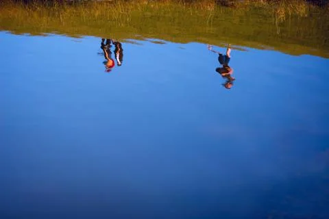 Reflection Of People In A Pond Stock Photos