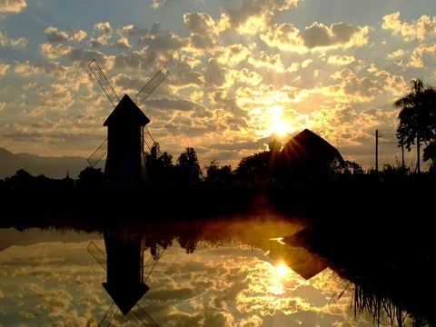 Reflection of people in silhouette walking around a lake at sunset Stock Footage 70986641