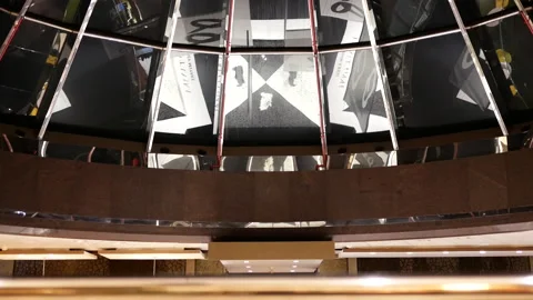 Reflection of people taking escalator inside shopping mall main entrance Stock Footage 103445141